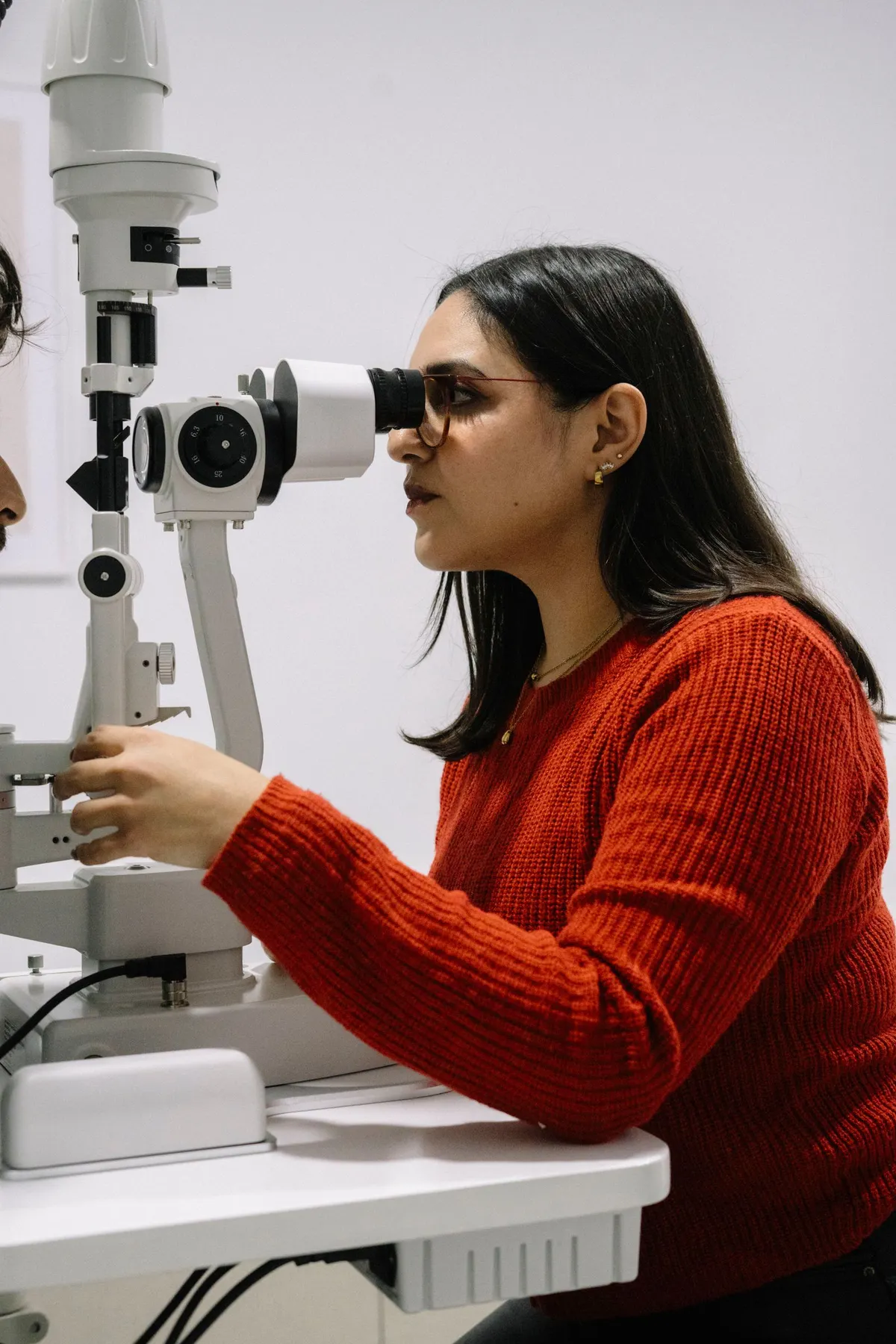Profesional realizando una valoración visual con equipo de optometría, fotografía de referencia